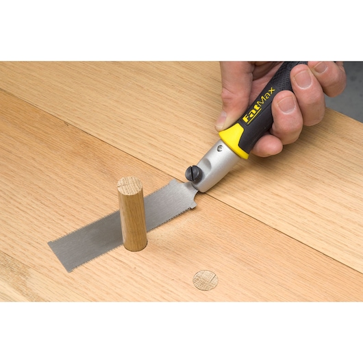 STANLEY 0-20-331 flush cut saw with black and yellow handle cutting wood dowel, close-up photo.