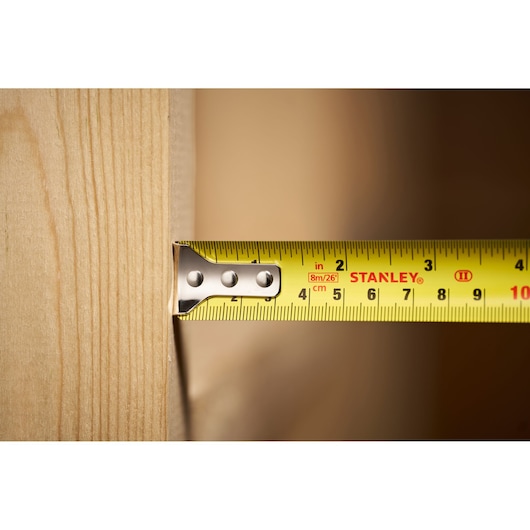 STANLEY 0-30-656 tape measure extended against wooden surface, close-up showing measurement marks.