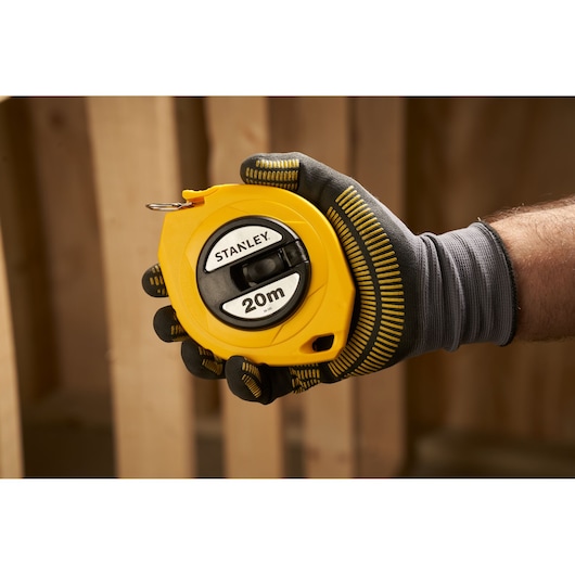 STANLEY 0-34-105 yellow 20m tape measure held in a gloved hand during use.