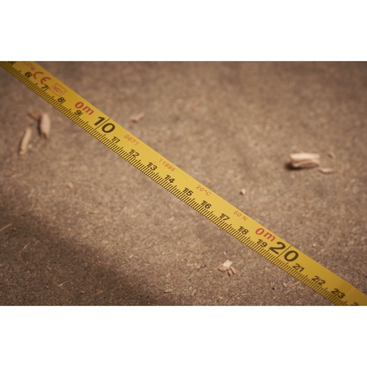 STANLEY 0-34-406 measuring tape close-up, showing yellow metric scale on sandy ground.