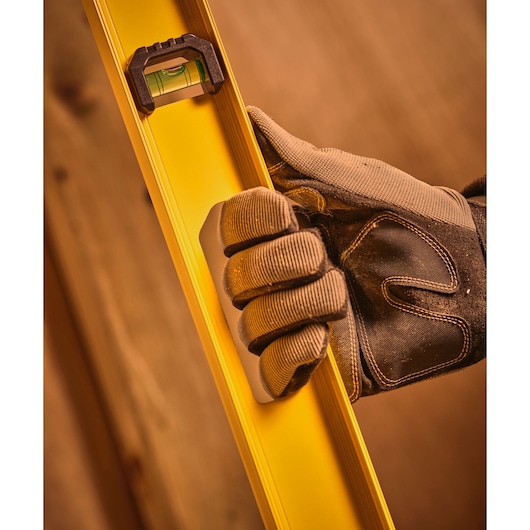 STANLEY 0-42-074 photography close-up of gloved hand holding yellow spirit level.