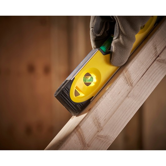 STANLEY 0-43-511 spirit level held against wood, close-up photography of tool in use.