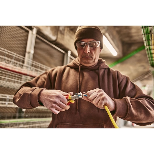 STANLEY 0-84-010 pliers in use stripping yellow wire, closeup photo, product category photography.