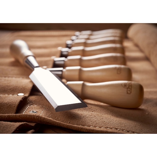 STANLEY 1-16-793 wood chisel set with wooden handles on brown suede roll, angled close-up.