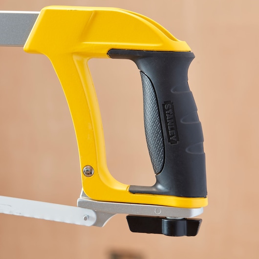 Stanley 1-20-110 hacksaw close-up showing yellow frame and ergonomic black handle.