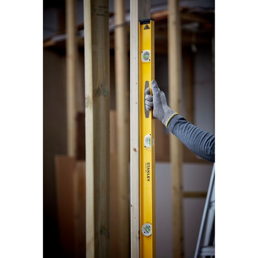 Photo of STANLEY 1-42-922 spirit level used vertically on wood frame construction.