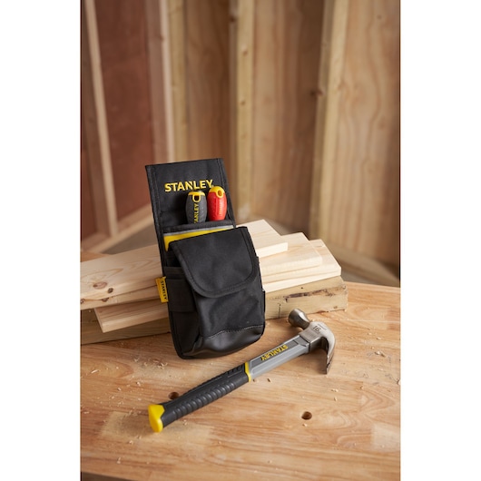 STANLEY 1-93-329 tool pouch with two screwdrivers and hammer on a wooden workbench in workshop.