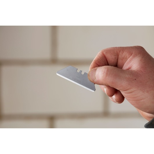 Photo of STANLEY 2-11-987 utility blade held in hand, silver color, close-up view.