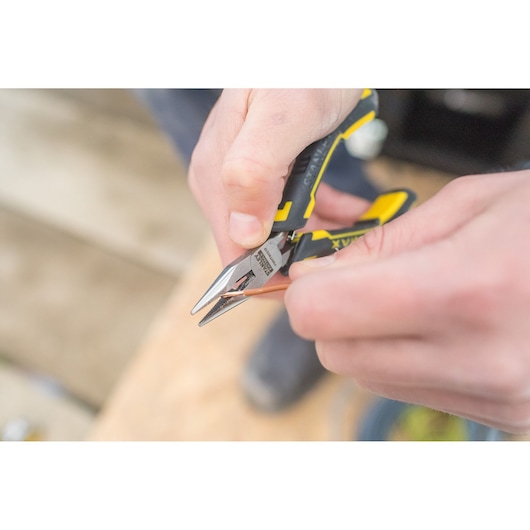 Photo of STANLEY FMHT0-80541 pliers with black and yellow handle cutting a copper wire.