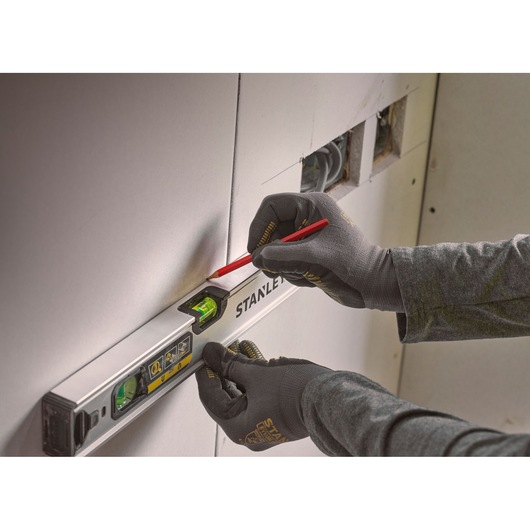 STANLEY FMHT43670-1 spirit level in use for marking on drywall, close-up photography.