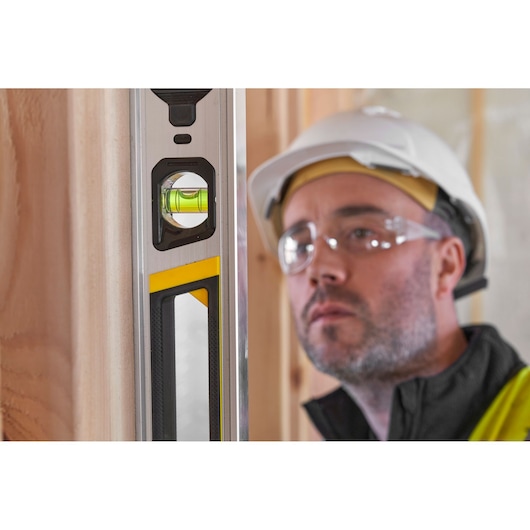 STANLEY FMHT43674-1 spirit level close-up with clear vial, photography on construction site.