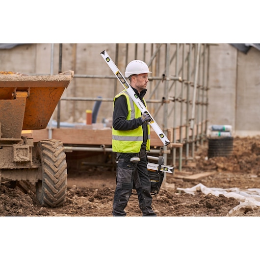 Photo of STANLEY FMHT43674-1 spirit level held by worker on construction site.