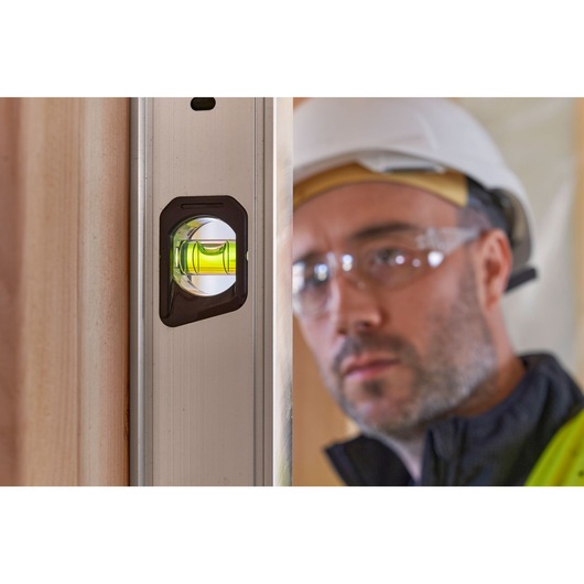 STANLEY FMHT43679-1 aluminum spirit level close-up showing vial in use, construction context.