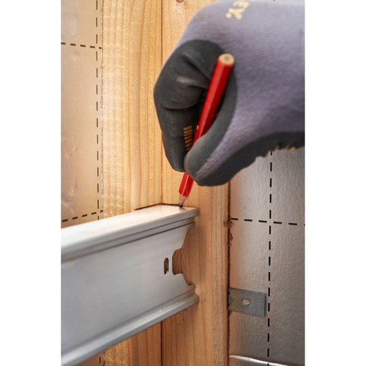 STANLEY FMHT43680-1 photography of gloved hand marking wood with red pencil near metal rail.