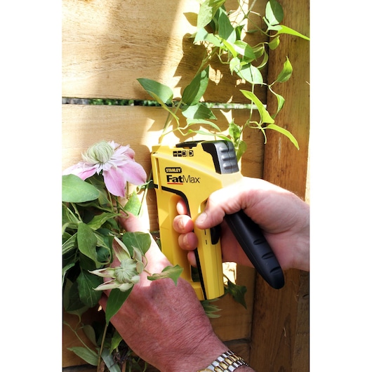 Photo of STANLEY FMHT6-70411 stapler securing flower stem to wooden board.