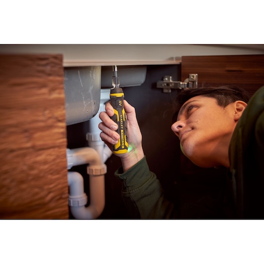 STANLEY FMHT66719-0 ratcheting screwdriver used for plumbing repair under sink.