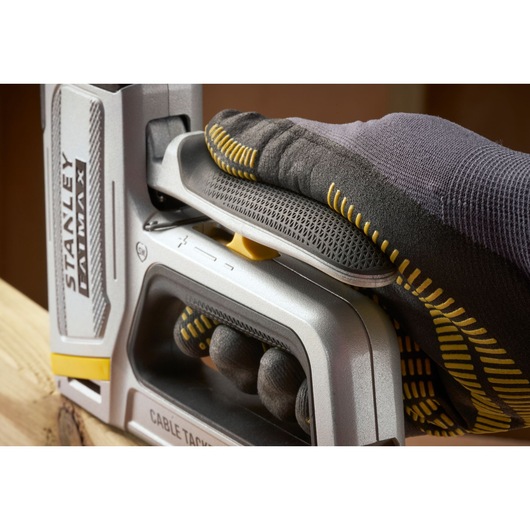Photo of STANLEY FMHT70100-0 cable tack stapler held by gloved hand, angled view.
