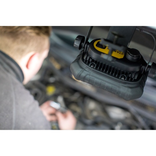 STANLEY FMHT81507-1 work light in use above car engine, close-up photography.