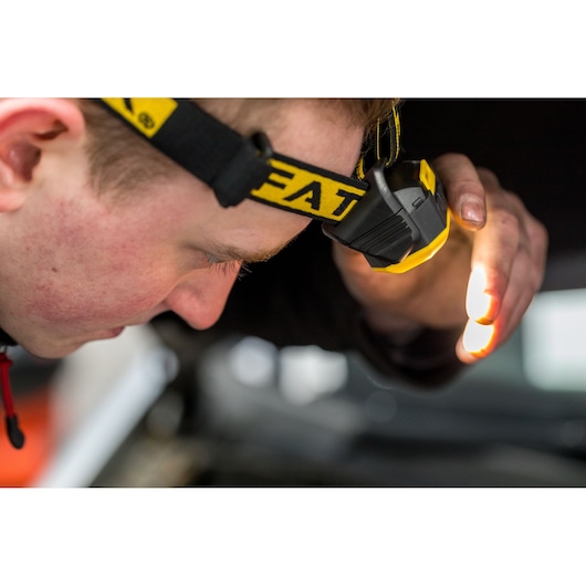 STANLEY FMHT81509-0 headlamp, yellow and black, worn during inspection, product detail photography.