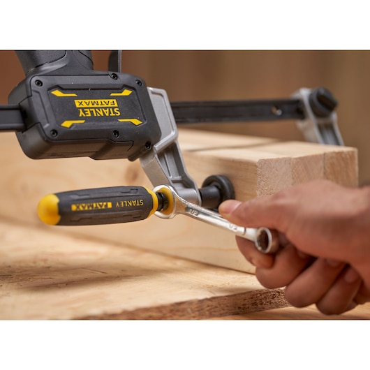 Photo of STANLEY FATMAX FMHT83008-0 clamp securing wood, close-up of handle and wrench adjustment.