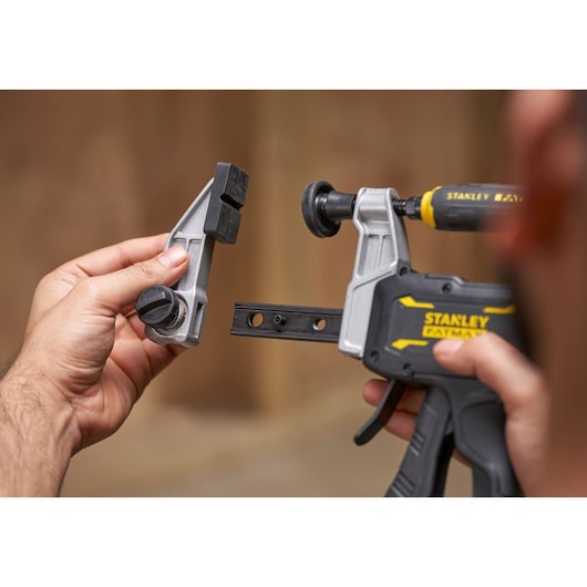 STANLEY FMHT83008-0 clamp being assembled, close-up of two hands attaching clamp parts.