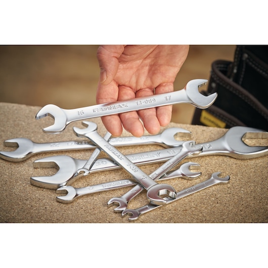 STANLEY FMMT13072-0 open-end wrenches set, silver, one held by hand, others on work surface.