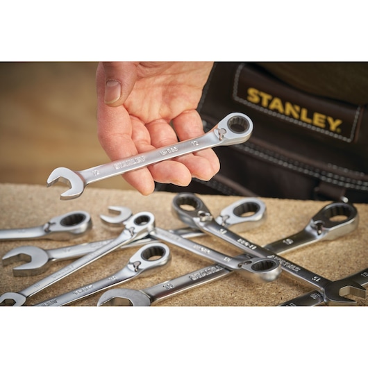 STANLEY FMMT13085-0 photography of silver ratcheting spanners held in hand, with tool belt and workbench.