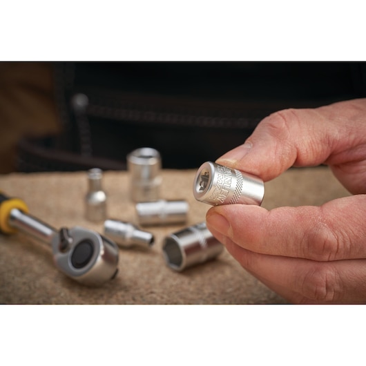 Photo of STANLEY FMMT17198-0 socket held in hand, with ratchet and other sockets on work surface.