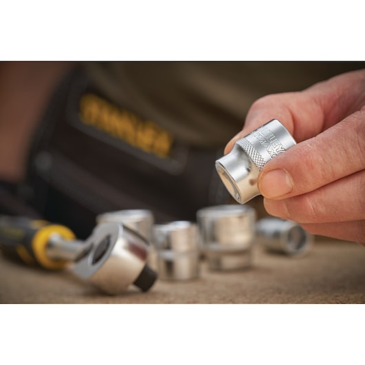 STANLEY FMMT17219-0 socket set photography, close-up with hand holding silver socket.