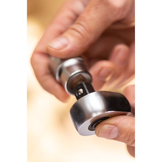 STANLEY FMMT17227-0 ratchet adapter photography, close-up of hand holding metal tool.