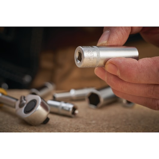 STANLEY FMMT17964-0 socket photography, close-up of silver socket held in hand with tools in background.