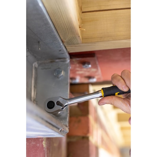 STANLEY FMMT82685-1 ratchet wrench in use tightening a bolt on metal beam, close-up angle.