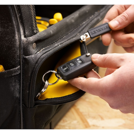 STANLEY FMST17626-1 tool bag close-up with zippered pocket, black with yellow interior, key and key fob visible.