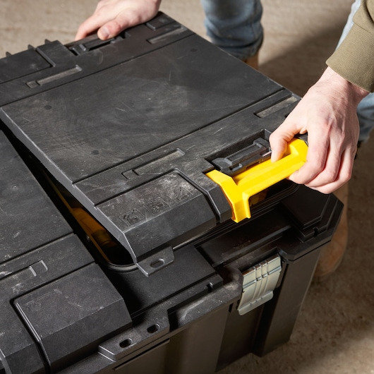 Photo of STANLEY FMST17870-1 black tool box with yellow handle being opened, angled close-up view.