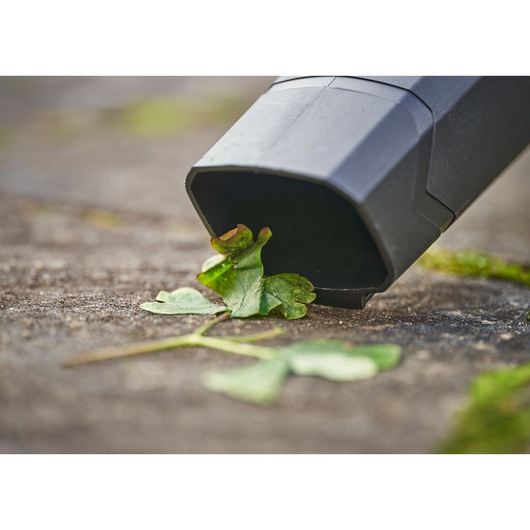 STANLEY SFMCBL714M1 blower nozzle close-up removing leaves on stone surface.