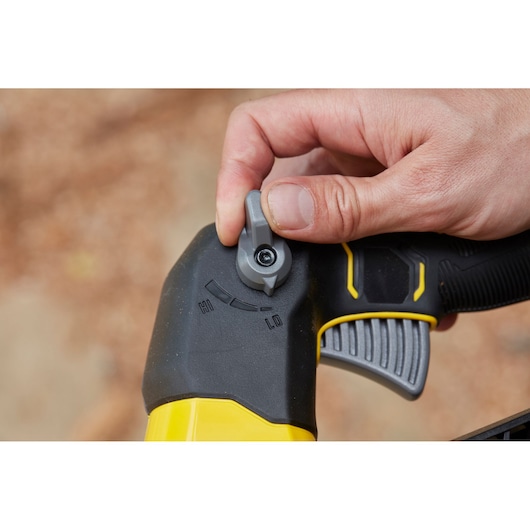 STANLEY SFMCBLB76B blower handle close-up with speed control dial, black and yellow, hand adjusting setting.