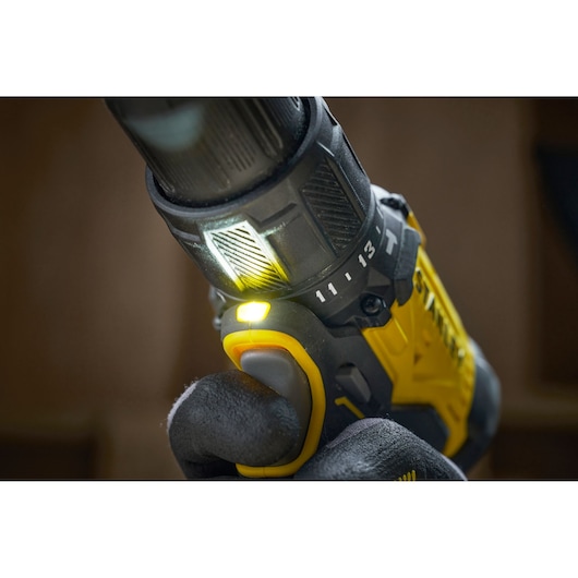 Close-up of a Stanley cordless drill in use, showing grip, trigger, and built-in LED light.