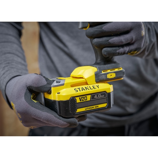 Stanley V20 cordless tool with 4.0Ah lithium-ion battery held by gloved hands.