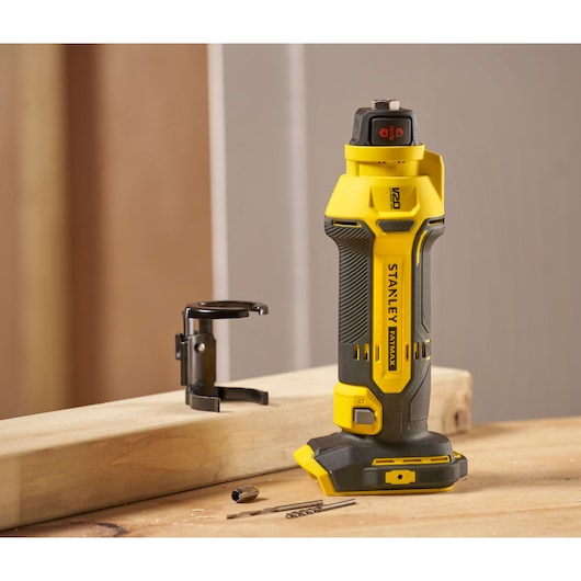 STANLEY SFMCE200B rotary tool in yellow and black, shown upright on a wooden surface with accessories nearby.