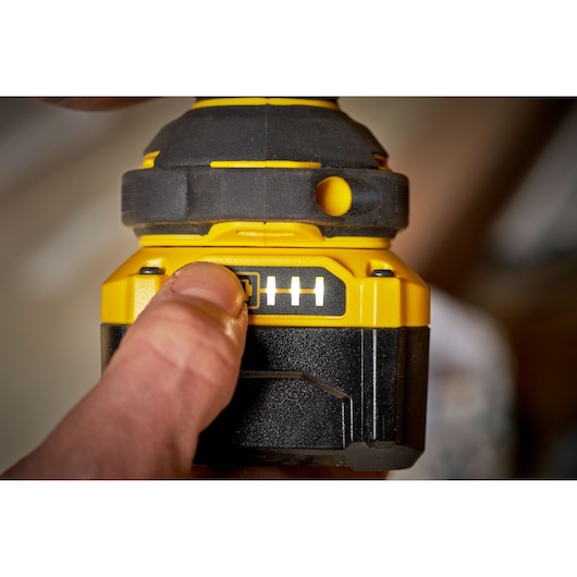 STANLEY SFMCF920B battery indicator on cordless tool, close-up view with finger pressing button.