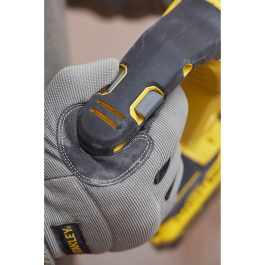 Photo of STANLEY SFMCH900M22 power tool handle with gloved hand gripping, close-up view.