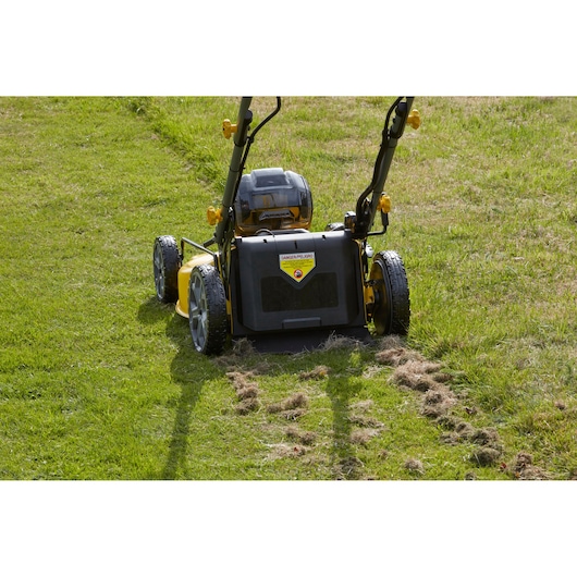 STANLEY SFMCMS2653B cordless lawn mower rear view on grass, yellow and black design, photography.