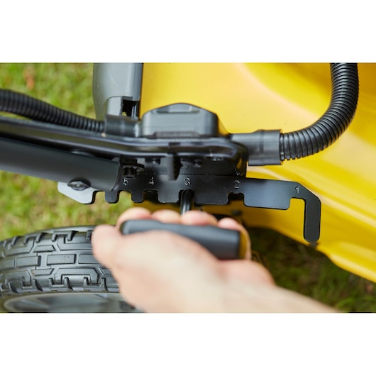 STANLEY SFMCMW2653B lawn mower height adjustment lever close-up with numbered settings, yellow body.