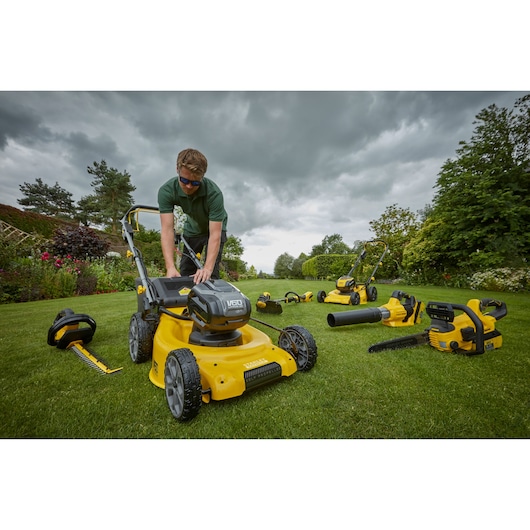 Photo of STANLEY SFMCMW2653B lawn mower with cordless garden tools on grass, outdoor setting.