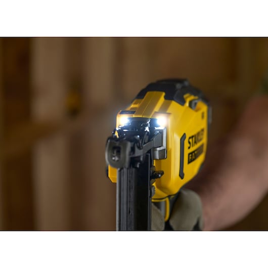STANLEY SFMCN616B nailer close-up with LED lights on, yellow and black tool in use.