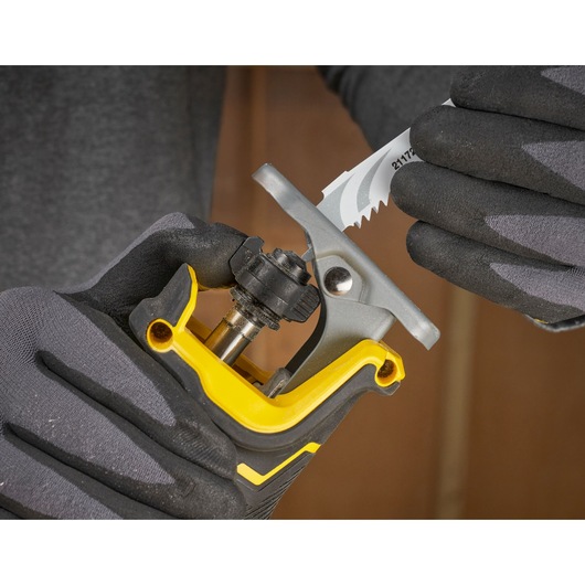 STANLEY SFMCS311M1T jigsaw blade being installed, close-up with gloved hands, tool details visible.