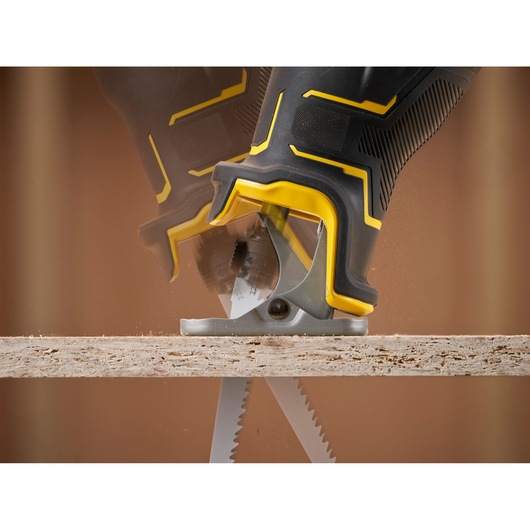 STANLEY SFMCS311M1T reciprocating saw cutting wood, close-up side angle, black and yellow handle.
