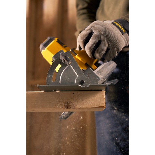 STANLEY SFMCS500M1S circular saw cutting wood, close-up action shot with gloved hand.
