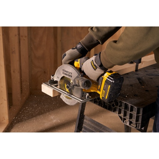 Stanley SFMCS500M1S circular saw cutting wood, close-up, user wearing gloves.