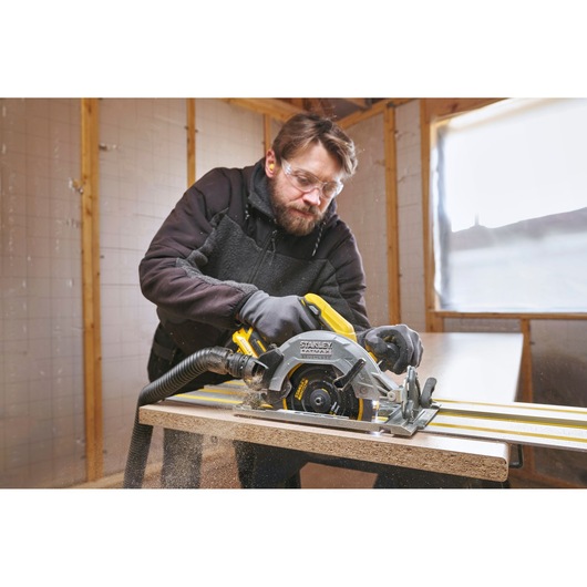STANLEY SFMCS551M1T circular saw used on wood in workshop, close-up showing tool in action.